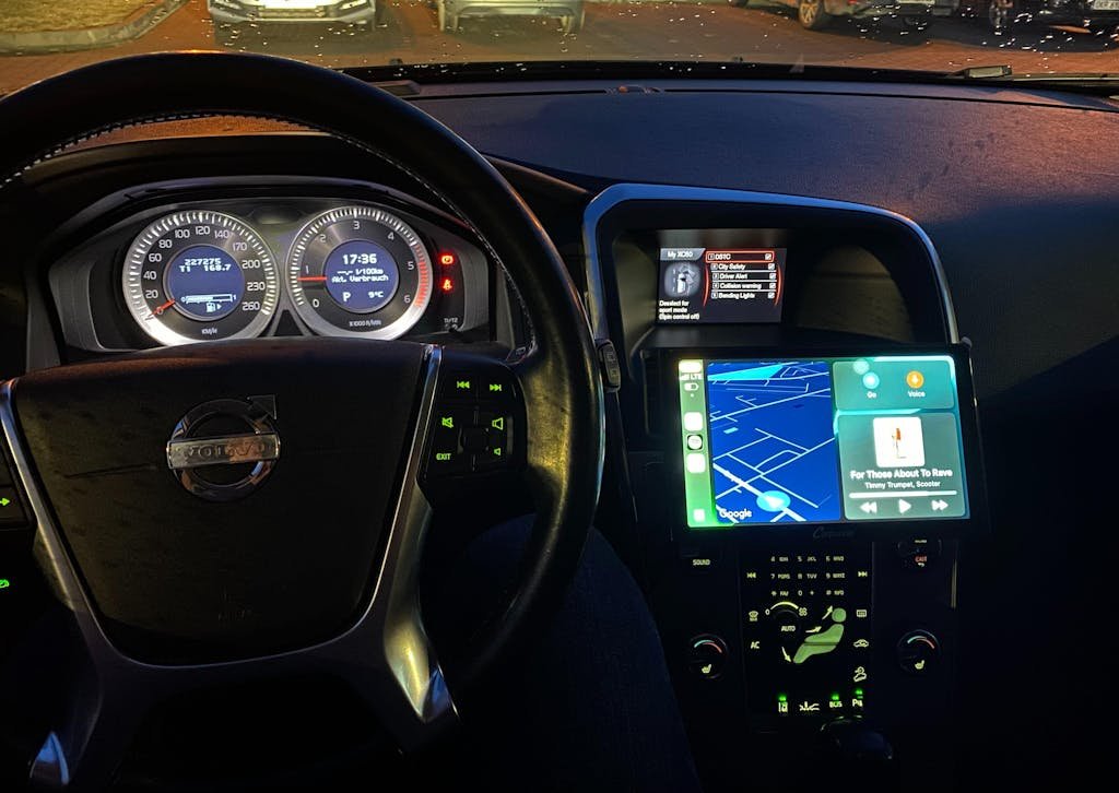 Painel de carro moderno com Apple CarPlay ativo exibindo Waze e Spotify